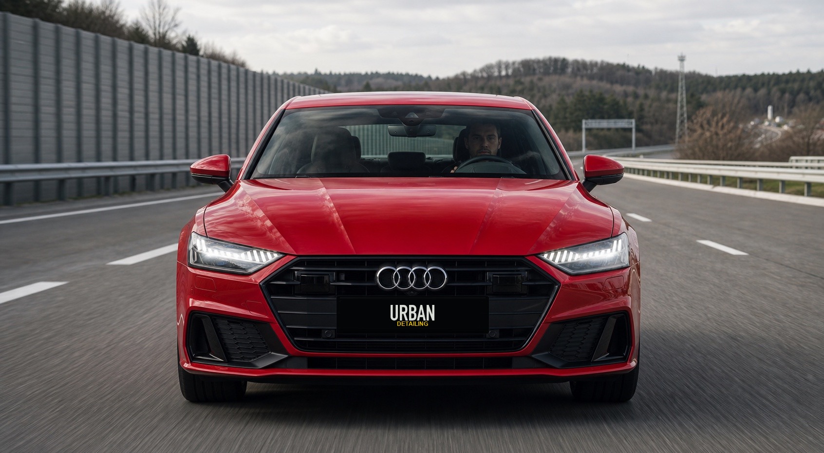 Красный Audi с водителем и брендированным номером Urban Detailing на трассе с отмеченными зонами риска
